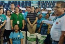 Bago City agriculturist Carlito Indencia (right) with farmers who received an initial 3,000 bags of certified rice seeds from the Department of Agriculture in Western Visayas during the turn-over rites at the Manuel Y. Torres Memorial Coliseum and Cultural Center on Dec. 12. PHOTO COURTESY OF BAGO CITY AGRICULTURE OFFICE
