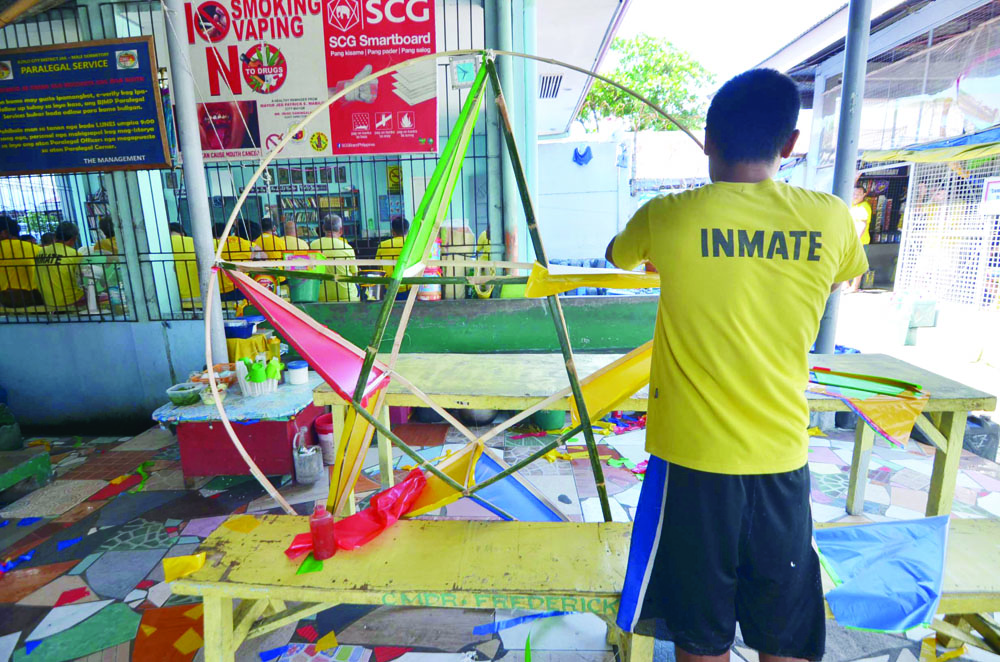 An inmate crafts a Christmas lantern out of plastic charol, bamboo sticks and small light bulbs to flicker when lit at night. IAN PAUL CORDERO/PN