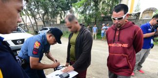 Police officers inspect items recovered from Gidney Boy Torrato. Torrato was nabbed in entrapment operation after he sold a sachet of suspected marijuana to a poseur-buyer on Dec. 17. IAN PAUL CORDERO/PN