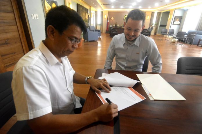Marcelo Cacho PECO Iloilo City Treasurer Jinny Hermano receives this check amounting to P134.9 million from Panay Electric Co. administrative manager Marcelo Cacho as the company’s payment for a decade of long-overdue real property taxes. CITY MAYOR’S OFFICE PHOTO