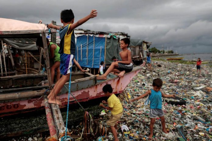 Children play on a boat docked on the garbage-filled shore of Baseco Beach in Tondo, Manila, Philippines. REUTERS