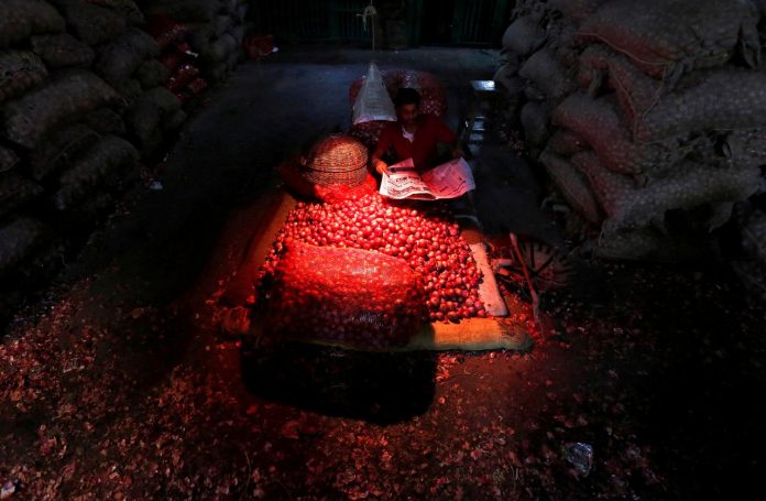 Vendor A vendor reads newspaper as he waits for customers at a wholesale onion market. RUPAK DE CHOWDHURI/REUTERS
