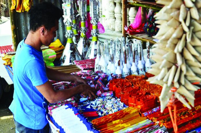 A firecracker vendor in Tigbauan, Iloilo attends to his goods. Firecrackers can only be sold in designated zones set by the local government unit in coordination with the Philippine National Police and the Bureau of Fire Protection. Panay News