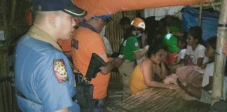 A police officer and rescue personnel assist the family of Jestoni Cabrillos who drowned in a river in Barangay Nanca, E.B. Magalona, Negros Occidental on Jan. 15. E.B. MAGALONA MUNICIPAL POLICE STATION