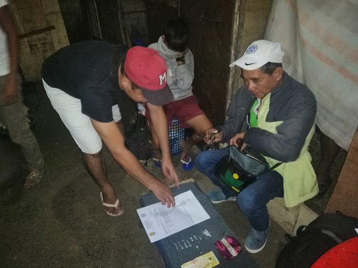 Angelica Unggod Antidrug officers inspect the items seized from Angelica Unggod during an entrapment operation in Barangay Vista Alegre, Bacolod City on Jan 5. POLICE STATION 7/BCPO