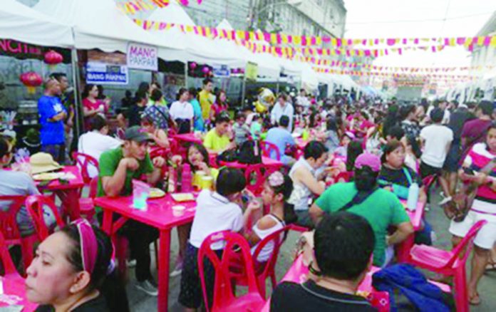B1 - Banner Revelers flock in Asenal Street, Iloilo City. Non-profit group “Kaon ‘Ta, Ilolio” is happy to serve the Ilonggos and to support as well the budding food businesses in Iloilo, says group’s administrator J Scott Sarria. PNA ILOILO