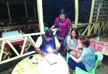 An antidrug officer inspects items seized from Angielyn Marba and Andrew Delasan. Marba and Delasan were nabbed in an entrapment operation in Barangay Punta Taytay, Bacolod City. POLICE STATION 9/ BCPO