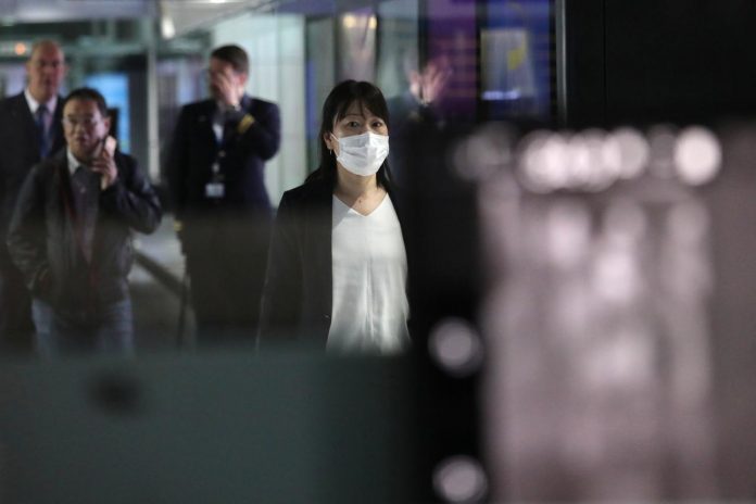 A woman with mask passes by thermal screening point at the international arrival terminal of Kuala Lumpur International Airport in Sepang, Malaysia on Jan. 21. REUTERS/LIM HUEY TENG