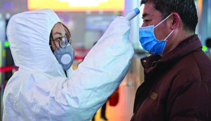 Coronavirus A medical worker checks a passenger’s temperature at Nanjing South Railway station on Monday, Jan. 27. EPA-EFE