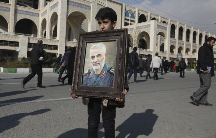 Gen. Qassem Soleimani A boy carries a portrait of Iranian Revolutionary Guard Gen. Qassem Soleimani, who was killed in the United States airstrike in Iraq, prior to the Friday prayers in Tehran, Iran, Jan. 3, 2020. AP