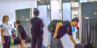 TIGHT SCREENING. As two alert airport security personnel watch, newly-arrived airline passengers pick up their baggage from conveyors after undergoing x-ray inspection at the Iloilo Airport in Cabatuan, Iloilo. The Bureau of Quarantine has deployed personnel in all airports to screen travelers as authorities try to prevent the entry of a mystery virus from China. IAN PAUL CORDERO/PN
