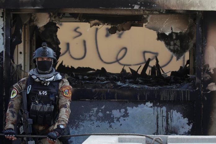 A member of the Iraqi security forces stands guard during a protest to condemn air strikes on bases belonging to Hashd al-Shaabi (paramilitary forces) in Baghdad, Iraq on Jan. 1. REUTERS/KHALID AL-MOUSILY