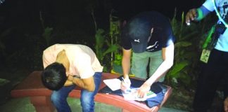 An antidrug officer inspects items recovered from Jovy Treyes. Treyes was nabbed after he sold a sachet of suspected shabu to a poseur-buyer in an entrapment operation in Barangay Singcang-Airport, Bacolod City. POLICE STATION 8/ BCPO