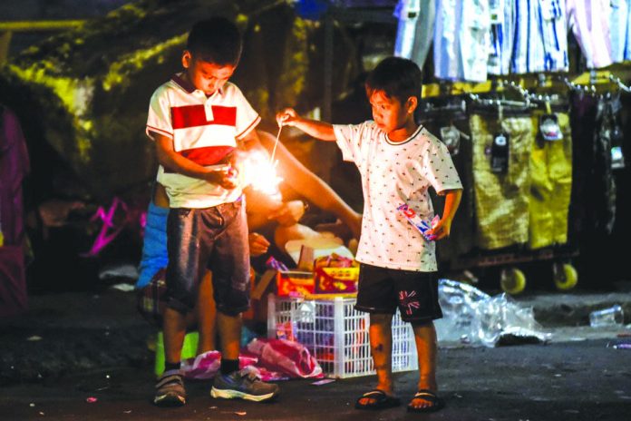 Children play with sparklers at Divisoria market in Manila on Tuesday. Authorities have banned the use of dangerous firecrackers, prompting New Year revelers to buy safer alternatives, such as party horns and harmless firecrackers. ABS-CBN NEWS