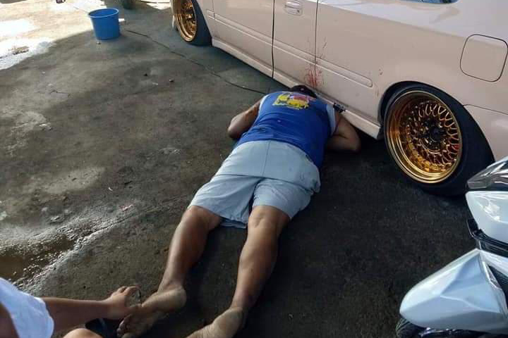 Onel Arandez, councilman of Barangay Punta Tabuc, lies lifeless on the ground after two of the three unidentified suspects peppered him with bullets at a repair shop in Barangay Cagay, Roxas City, Capiz yesterday. GLENN BEUP/PN