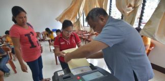 An election officer helps a person with disability feed her ballot into the vote-counting machine during a simulation voting at Central Philippine University in Iloilo City on Jan. 21, 2019. The simulation is a project of the Commission on Elections to further fine-tune the voting processes for persons with disability. IAN PAUL CORDERO/PN