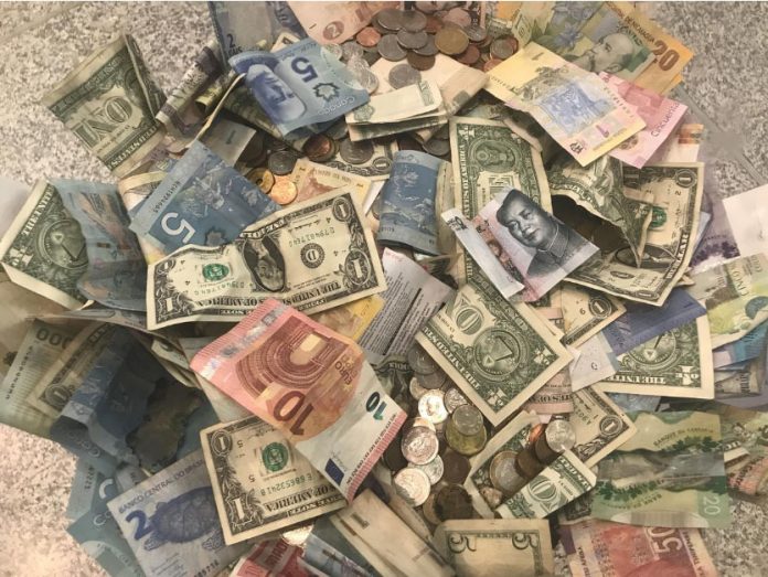 US dollar United States dollars and other world currencies lie in a charity receptacle at Pearson international airport in Toronto, Ontario, Canada. REUTERS
