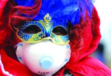 Venice Carnival closes as Italy imposes lockdown A Carnevale di Venezia participant in Italy wears two masks – a carnival mask for the festival and a facemask to avoid catching a new coronavirus. BBC