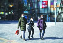 China virus cases pass 70,000 A family wears protective face masks outside an almost-empty Beijing shopping mall. AFP