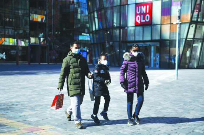 China virus cases A family wears protective face masks outside an almost-empty Beijing shopping mall. AFP