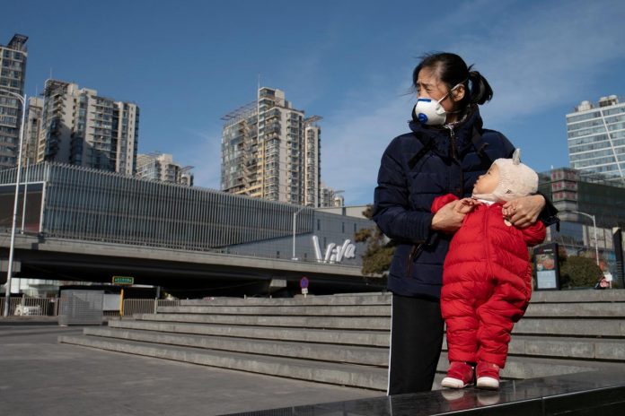 China’s new coronavirus infections hit daily record A woman wearing a face mask holds a child near a shopping mall in Beijing, China, as the country is hit by an outbreak of the new coronavirus on Feb. 1. REUTERS/STRINGER