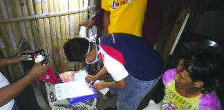 An antidrug officer inspects items seized from Darwin Tabotabo during an entrapment operation in Barangay 19, Bacolod City on Feb. 3. POLICE STATION 9/BCPO