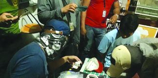 Antidrug officers inspect items seized from Jerenz Abuel. He was nabbed in an entrapment operation in Barangay Poblacion, Kalibo Aklan on Feb. 18. BOY RYAN ZABAL/PN