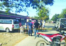Drugs suspect Von Adrian Segura sits as antidrug officers inspect items seized from him during an entrapment operation in Barangay Funda-Dalipe, San Jose, Antique on Feb. 16. STEPHEN LOUIE CHECA/PN