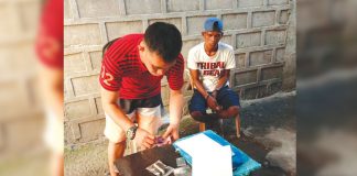 An antidrug officer inspects items seized from drug suspect Edmar Malunes. He was nabbed in an entrapment operation in his residence in Barangay 8, Bacolod City on Feb. 17. POLICE STATION 2/BCPO