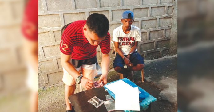 Edmar Malunes An antidrug officer inspects items seized from drug suspect Edmar Malunes. He was nabbed in an entrapment operation in his residence in Barangay 8, Bacolod City on Feb. 17. POLICE STATION 2/BCPO