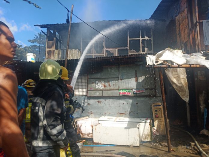 Firemen spray with water this house that fire struck in Barangay Tanza Esperanza, Iloilo City on Sunday, Feb. 23. The fire gutted a total of eight houses , four of which were totally destroyed. IAN PAUL CORDERO/PN