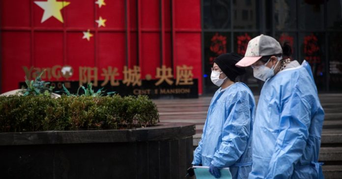 Daily Life In Wuhan During Lockdown Two women wear protective masks and gowns as they walk in the streets of Wuhan, China, on Feb. 10, 2020. Getty Images