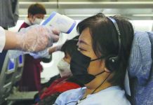 Stewardesses take temperatures of passengers as a preventive measure for the coronavirus on an Air China flight from Melbourne to Beijing before it land at Beijing Capital International Airport in China, Tuesday, Feb. 4, 2020. CHINATOPIX VIA AP