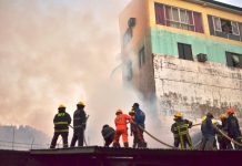 Twin city fires raze 11 houses TO THE RESCUE. Firefighters of the Bureau of Fire Protection in Iloilo City and from volunteer groups position themselves atop this roof to spray with water the houses burning behind a tall wall in Barangay Gloria, Iloilo City on Sunday afternoon, Feb. 16, 2020. This is the second fire to hit the city yesterday. In the morning, fire struck Barangay Concepcion also in the City Proper. IAN PAUL CORDERO/PN