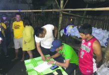 Antidrug personnel inspect items seized from John Mark Gabaleo. He was nabbed in an entrapment operation in Barangay Punta Taytay, Bacolod City. CDEU/BCPO