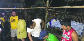 Antidrug personnel inspect items seized from John Mark Gabaleo. He was nabbed in an entrapment operation in Barangay Punta Taytay, Bacolod City. CDEU/BCPO