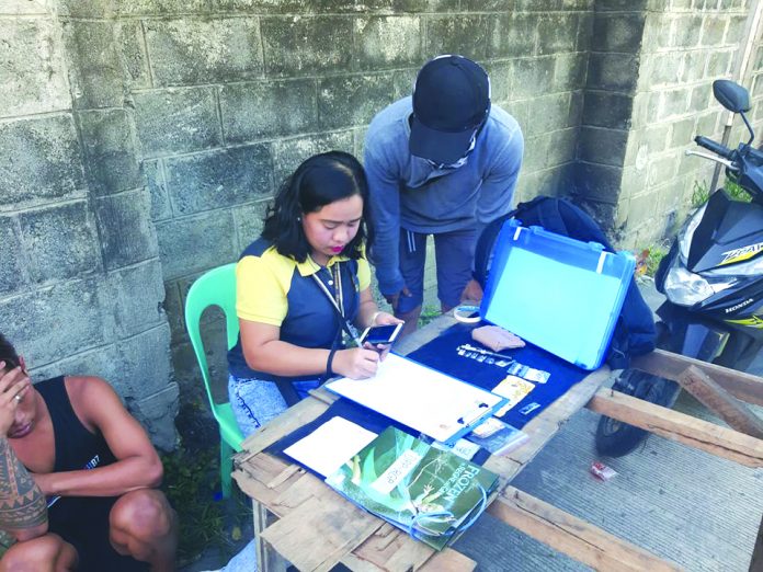 Minor falls in buy-bust Antidrug officers inspect items seized from a 17-year-old minor. He was nabbed in an entrapment operation in Barangay 2 on Feb. 15. POLICE STATION 2/BCPO