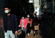 People wear protective masks as they walk outside a shopping mall at Causeway Bay, following the outbreak of the new coronavirus, in Hong Kong, China on Feb. 21, 2020. REUTERS