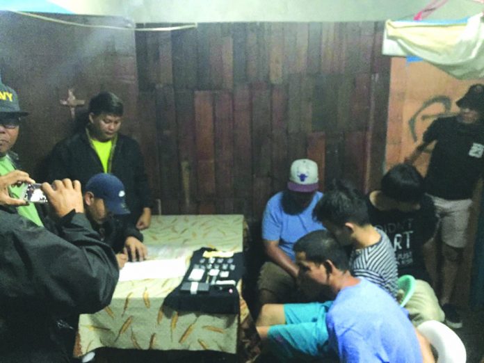 Antidrug personnel inspect items seized from Ritchie Manday, Nevin Gabines, Felomino Cordova and John Michael Shiung. The suspects were nabbed in an entrapment operation in Barangay Estefania, Bacolod City on Feb. 19. CDEU/BCPO