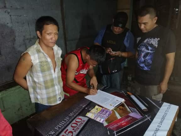 An antidrug officer inspects the items seized from drug suspect Sebastian Lo during an entrapment operation in Barangay 27, Bacolod City on Feb. 6. POLICE STATION 4/BCPO