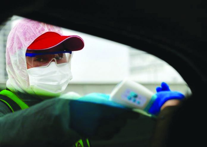 World 2 A worker takes body temperature measurement of a passenger inside a vehicle following an outbreak of the novel coronavirus in Wuhan, Hubei province, China Feb. 7, 2020. CHINA DAILY REUTERS