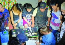 Antidrug officers inspect items seized from Samuel Sumagaysay, Melanie Del Valle and Sergion Rivera. The suspects were nabbed in an entrapment operation in Barangay 12, Bacolod City on Feb. 6. POLICE STATION 1/ BCPO