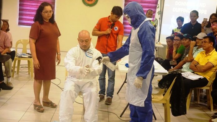 Personnel of the Bacolod City Disaster Risk Reduction and Management Office demonstrate how to put on personal protective equipment in case they are called to respond to confirmed coronavirus disease cases. The city government recently purchased at least 1,000 sets of personal protective equipment that P3,750 each. BACOLOD CITY PIO