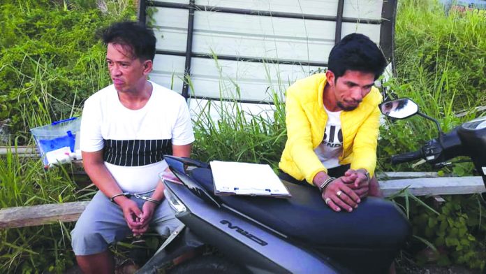 Drug suspects Alfred Jaguio and Feb Almia during an entrapment operation in Barangay Cagay, Roxas City, Capiz on Feb. 7. GLENN BEUP/PN