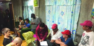 Antidrug operatives inspect items seized from George Bindol and Jared Villar. They were nabbed in an entrapment operation in Barangay Banago, Bacolod City on Feb. 22. CDEU/BCPO