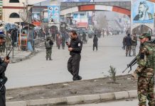 Afghan security forces personnel stand guard on a road near the site of a gun attack in Kabul March 6, 2020. AFP
