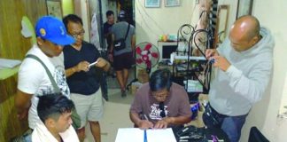 Antidrug officers inspect items seized from Mark Sy, who was nabbed in an entrapment operation in Barangay Estefania, Bacolod City on March 15. POLICE STATION 2/BCPO