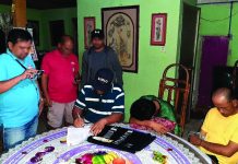 Antidrug officers inspect items seized from Ariel Julian and his son Arkiel. The suspects were caught in an entrapment operation in Barangay Mansilingan, Bacolod City yesterday. CDEU/BCPO
