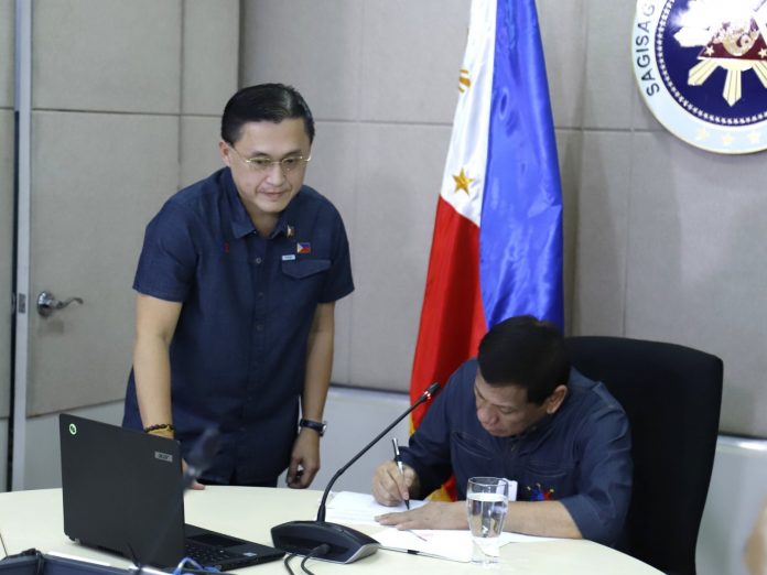 Bayanihan to Heal as One Act President Rodrigo Duterte with Sen. Christopher “Bong” Go is seen signing the “Bayanihan To Heal As One Act” that gives him the additional powers to address the COVID-19 pandemic. The Act was signed into law on March 24. CHRISTOPHER “BONG” GO