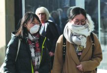 A pedestrian wearing a protective face mask walks in Princes Street in Edinburgh, Scotland, Britain on March 4. REUTERS/RUSSELL CHEYNE/FILE PHOTO